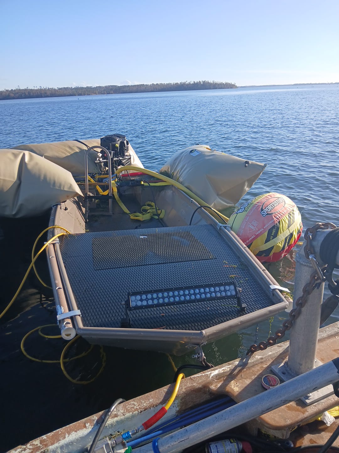 Small boat surrounded by flotation bags and recovery equipment