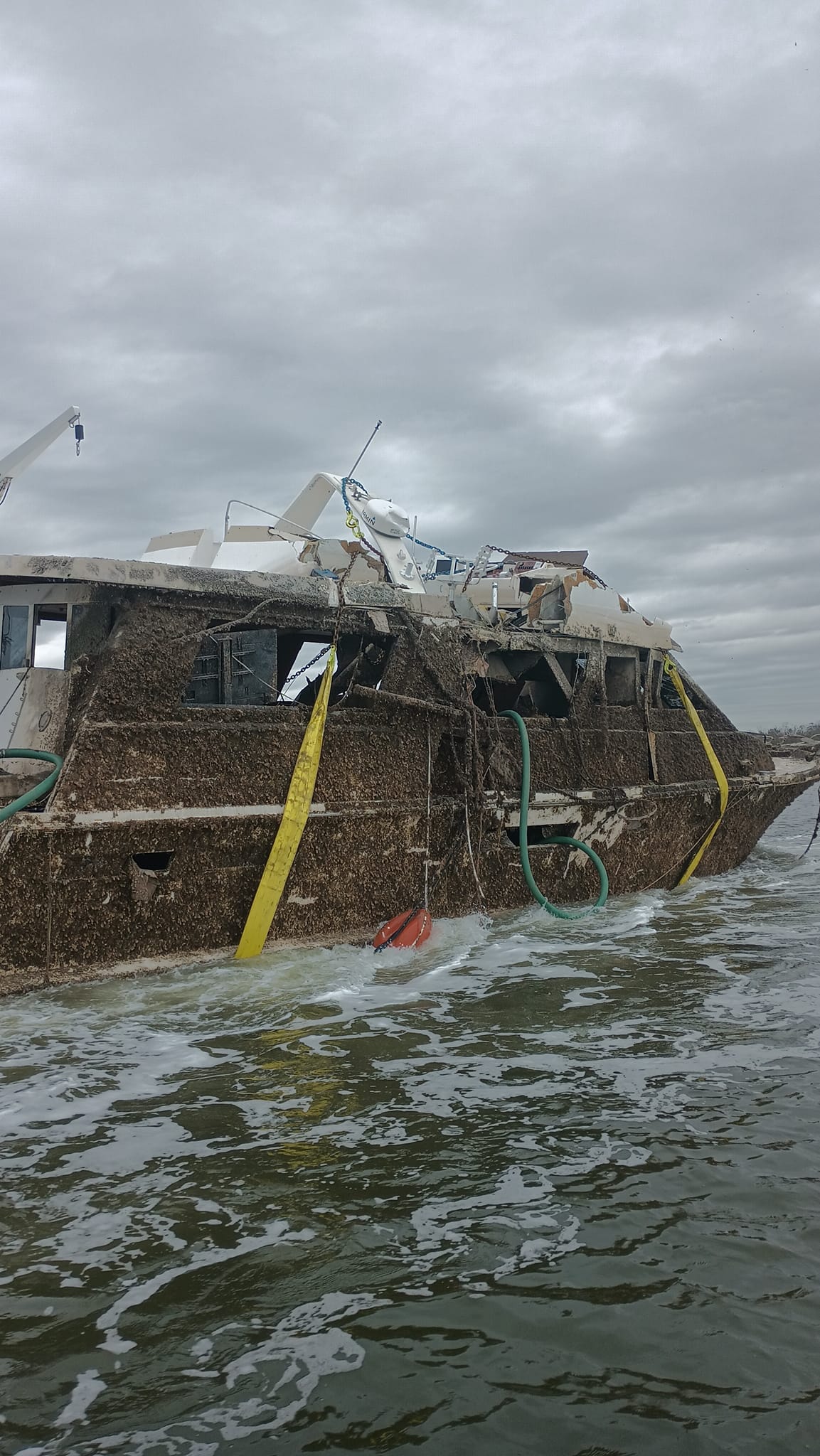 Side view of a weathered vessel with lifting straps