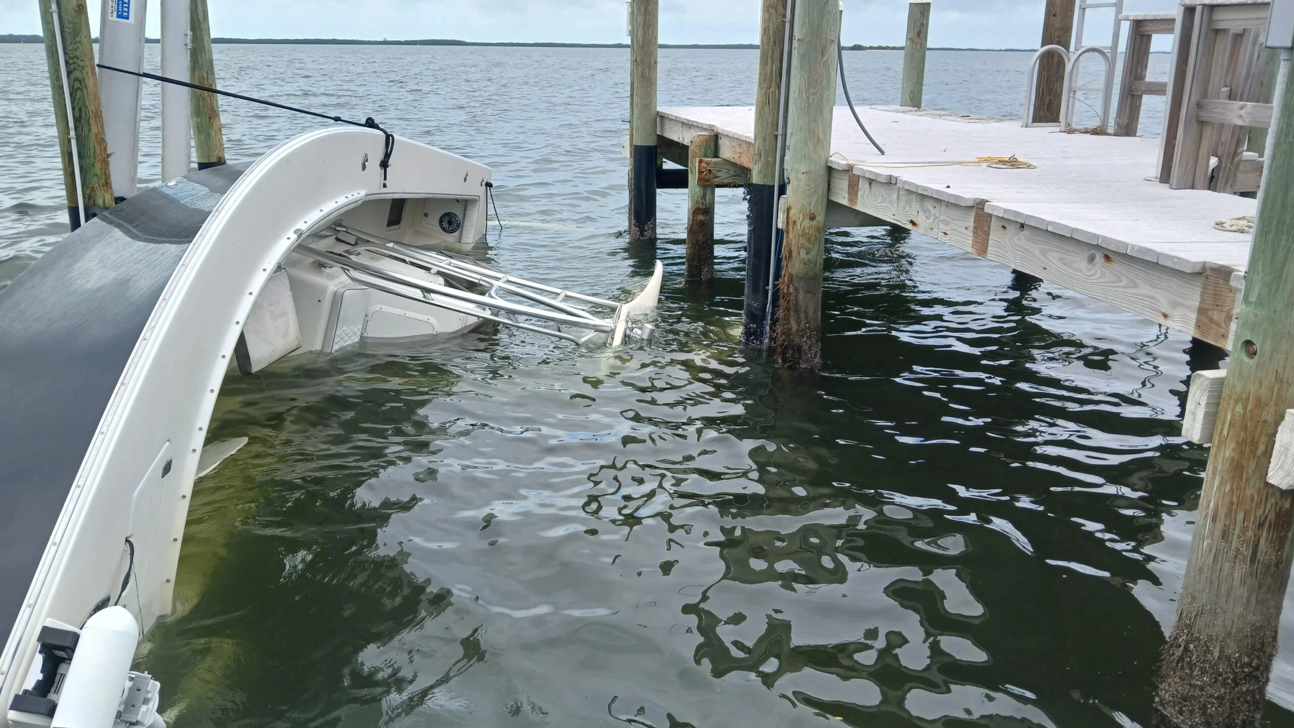 Partially submerged boat between dock pilings