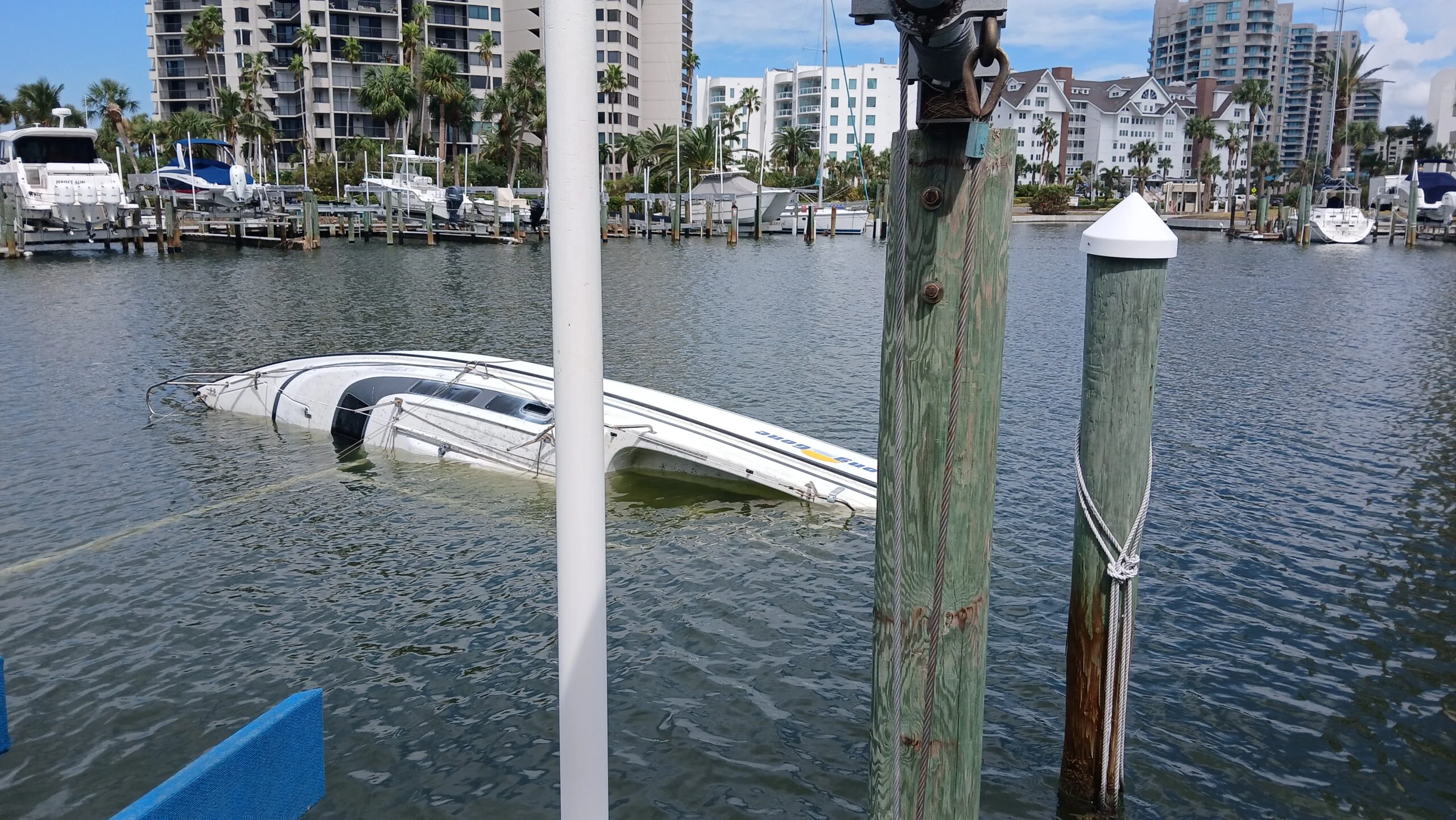 Mostly submerged boat alongside a dock