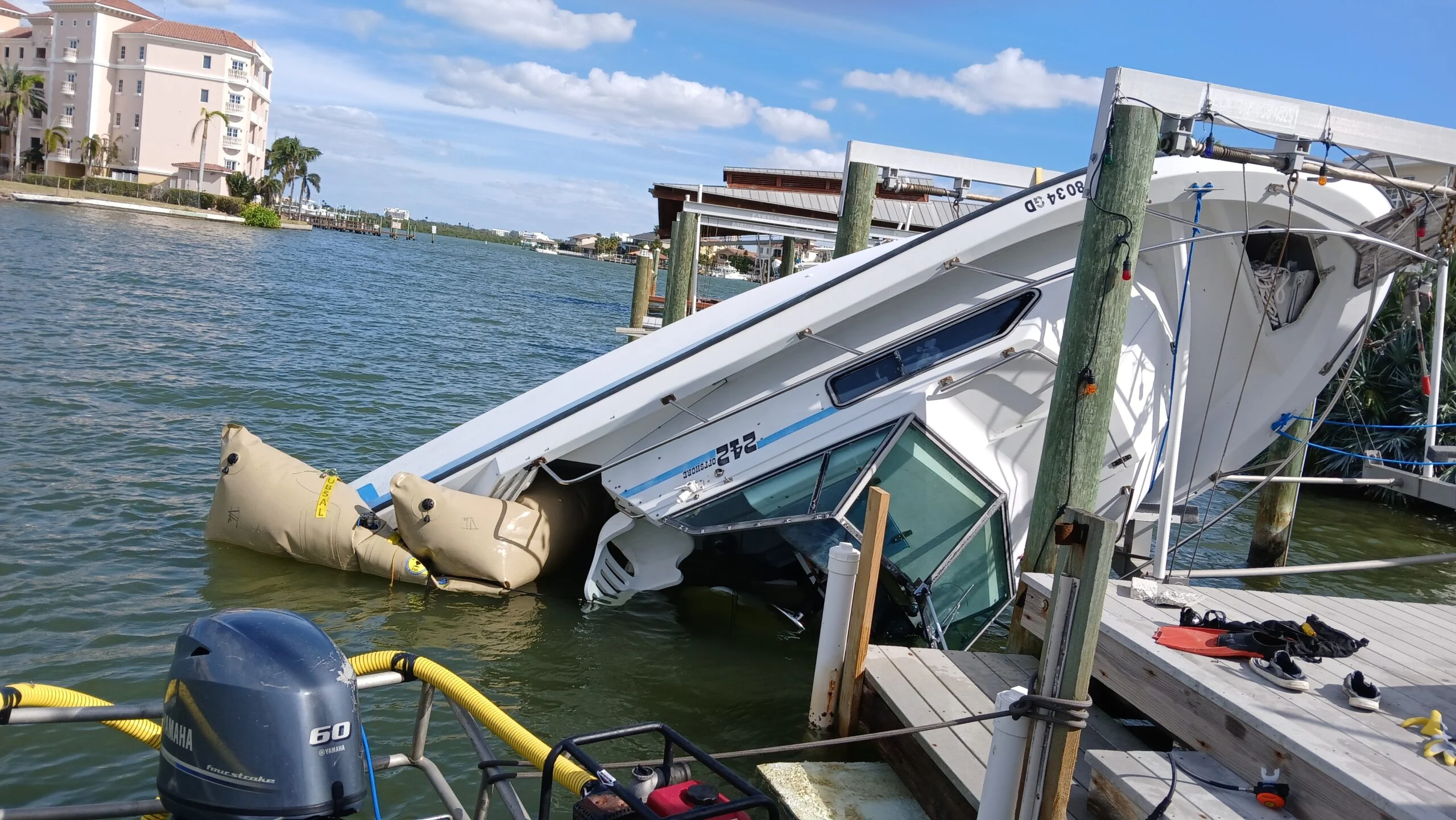 Listing boat beside a dock with lifting bags