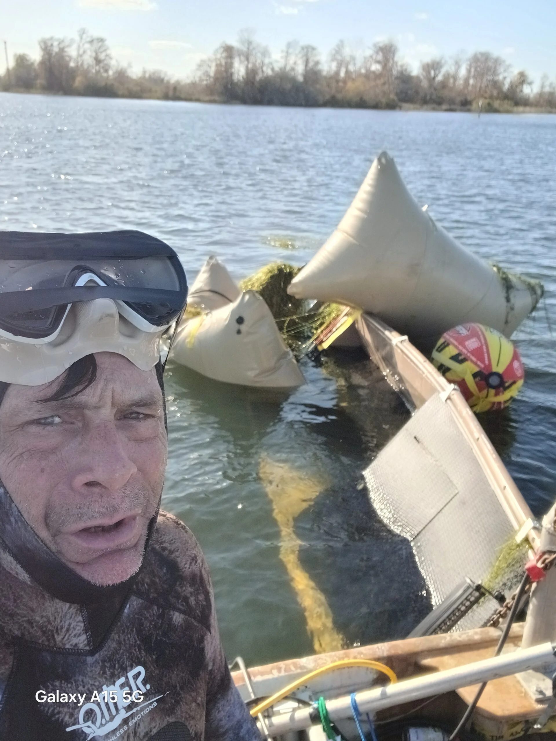 Crew beside a small vessel with flotation bags
